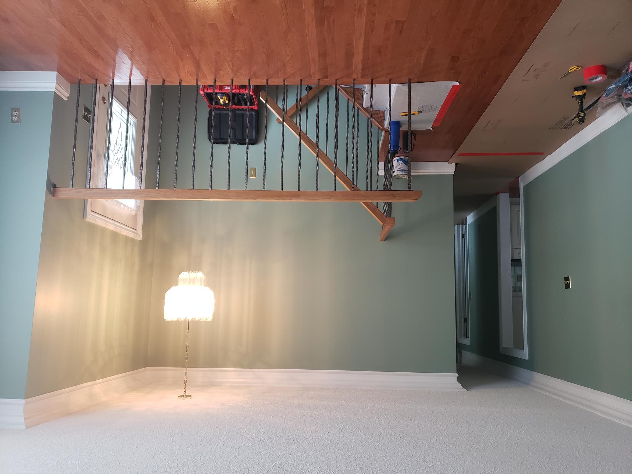 Open foyer and stair area before privacy wall